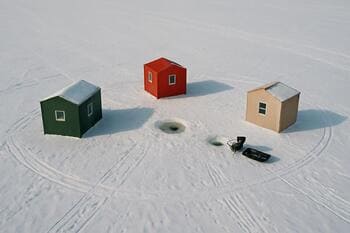 Top view of three ice shacks forming a ring on a frozen lake