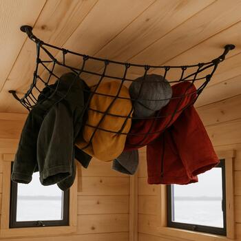 Ceiling net in an ice shack holding jackets and a folded blanket